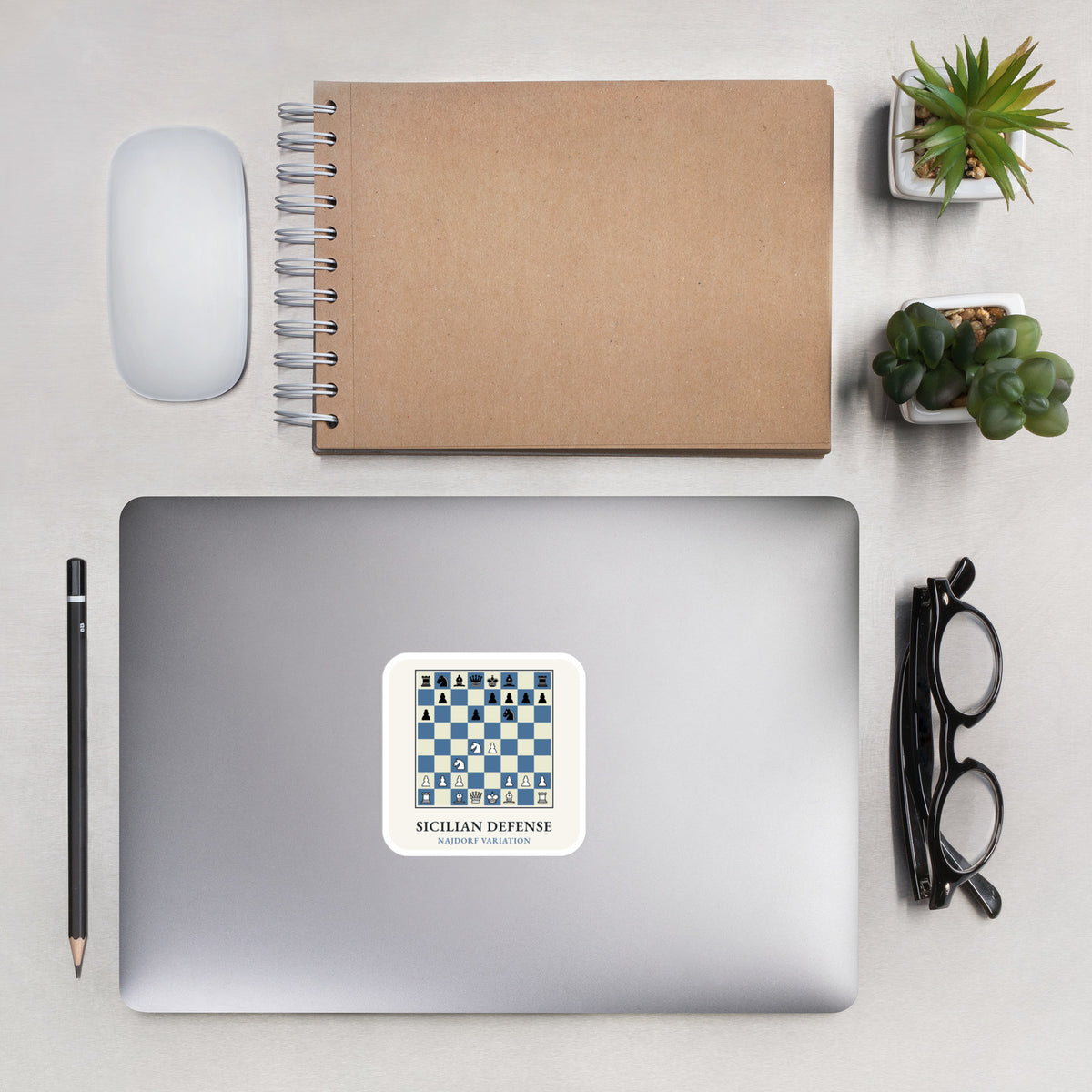 Sicilian Defense: Najdorf Variation Chess Sticker on a laptop next to a notebook